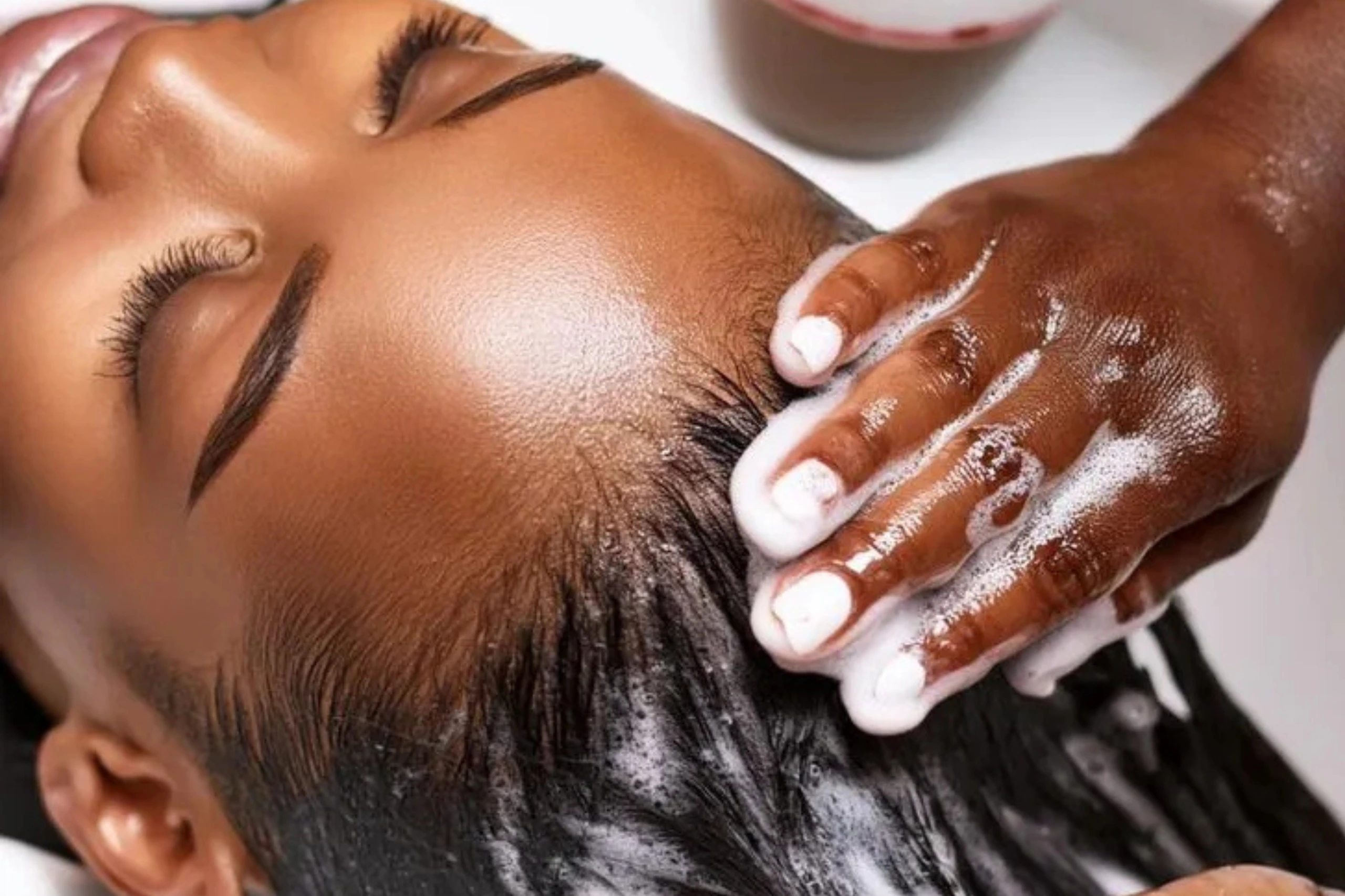Client receiving a scalp-first hair wash at Wash Bar for protective style prep.
